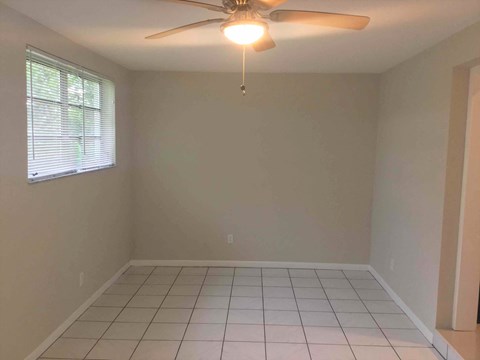 A room with a ceiling fan and a window.