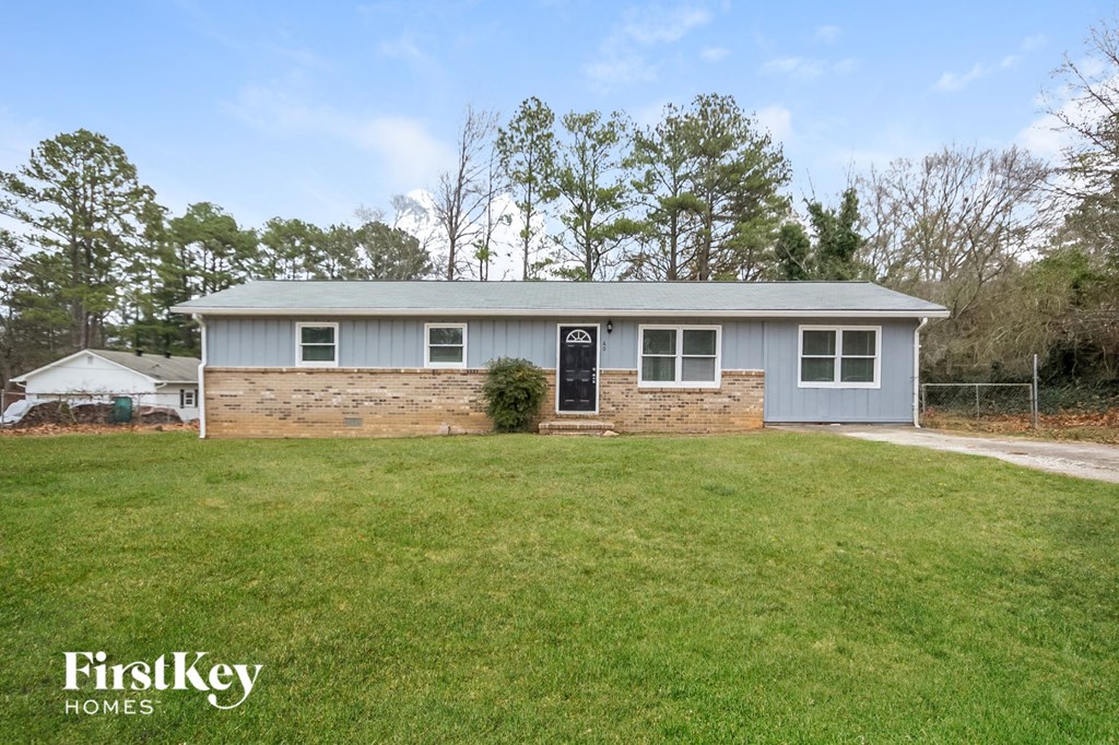 a blue house with a grassy yard and a black door