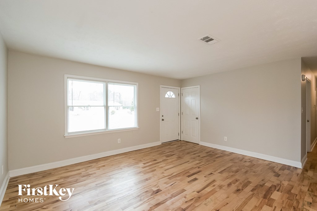 the living room of an empty house with wood flooring