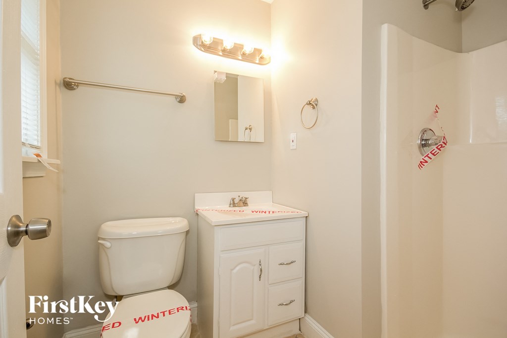 a bathroom with a toilet and a sink and a mirror