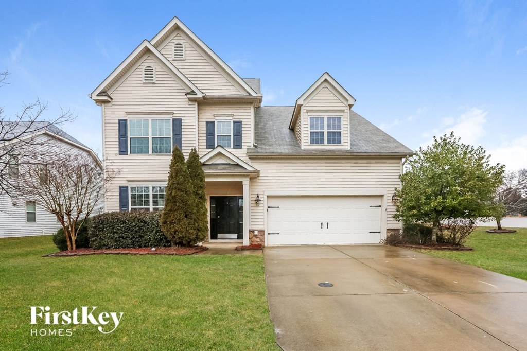 A large, two-story house with a garage is for sale.