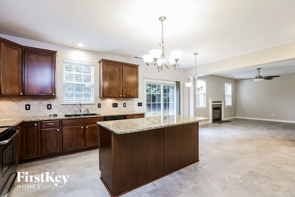 A kitchen with a marble countertop and wooden cabinets.