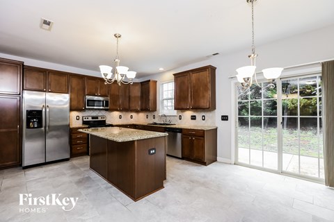 A kitchen with brown cabinets and a granite countertop.