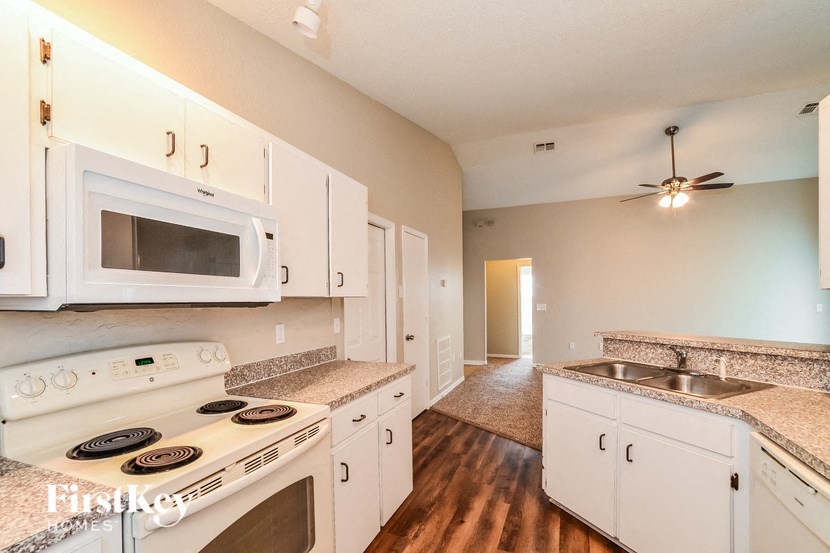 A kitchen with white appliances and cabinets.