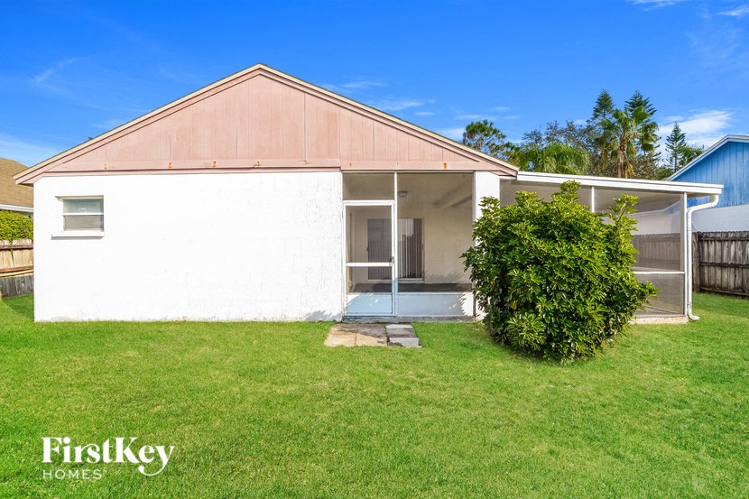 A house with a white exterior and a brown roof is for sale.