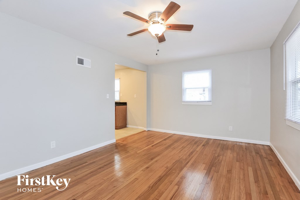 the living room and dining room with hardwood flooring and a ceiling fan