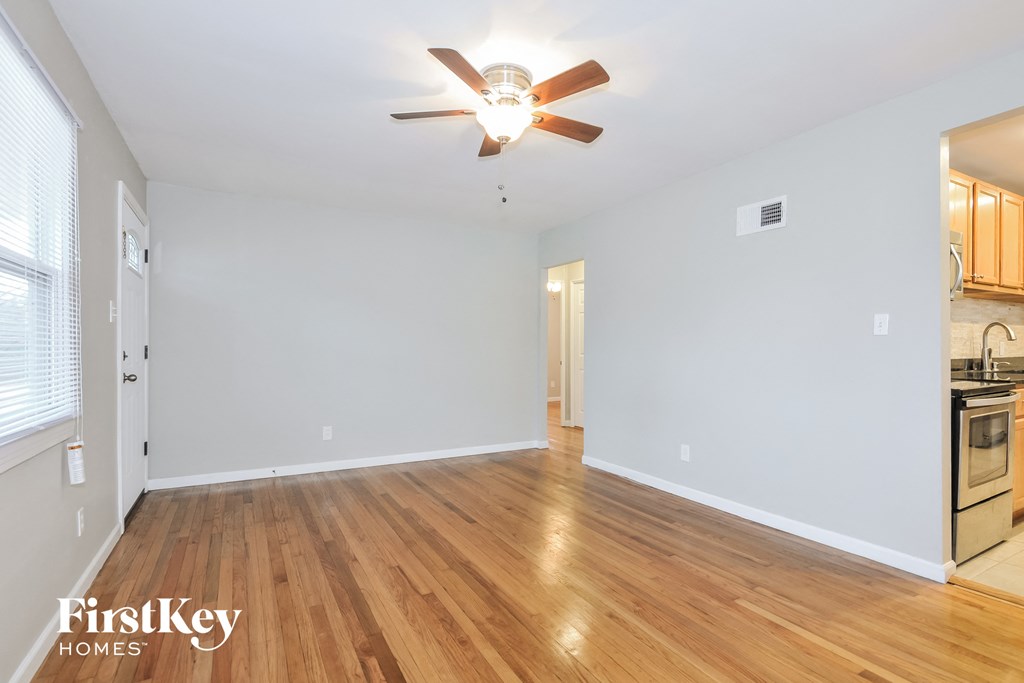 a living room with wood floors and a ceiling fan