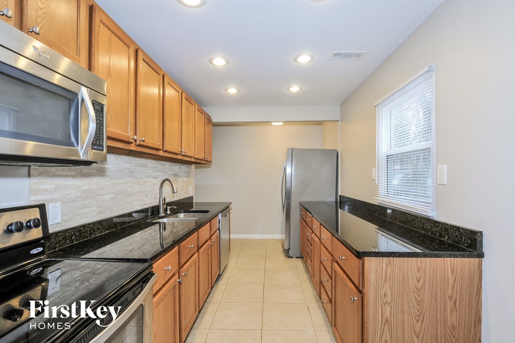 a kitchen with granite counter tops and stainless steel appliances and wooden cabinets