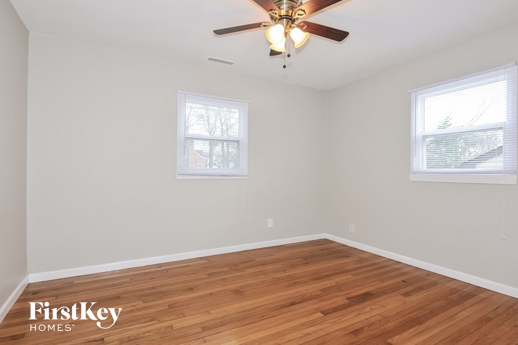 a living room with wood floors and a ceiling fan