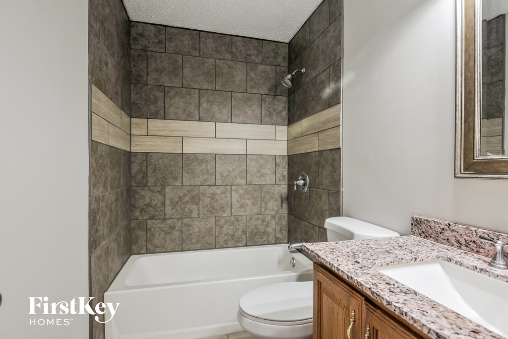 a bathroom with a toilet and a tub and a sink