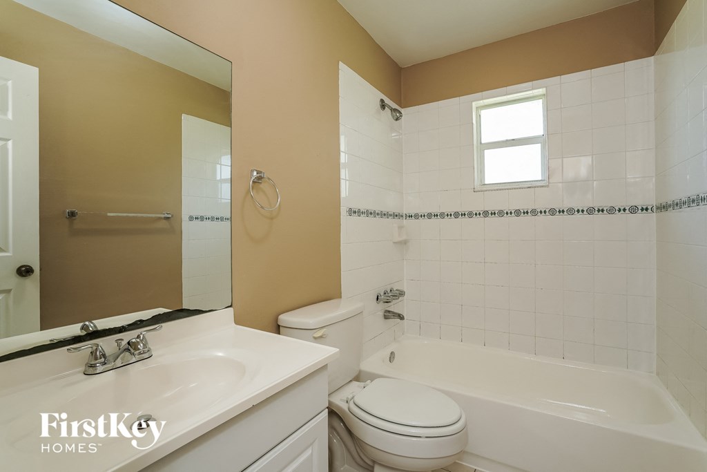 A bathroom with a white toilet, sink, and bathtub.