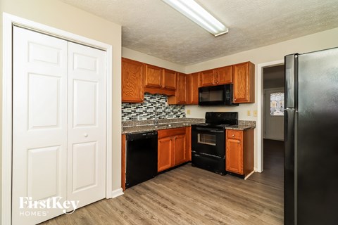 A kitchen with wooden cabinets and black appliances.