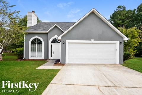 a gray house with a white garage door and a lawn