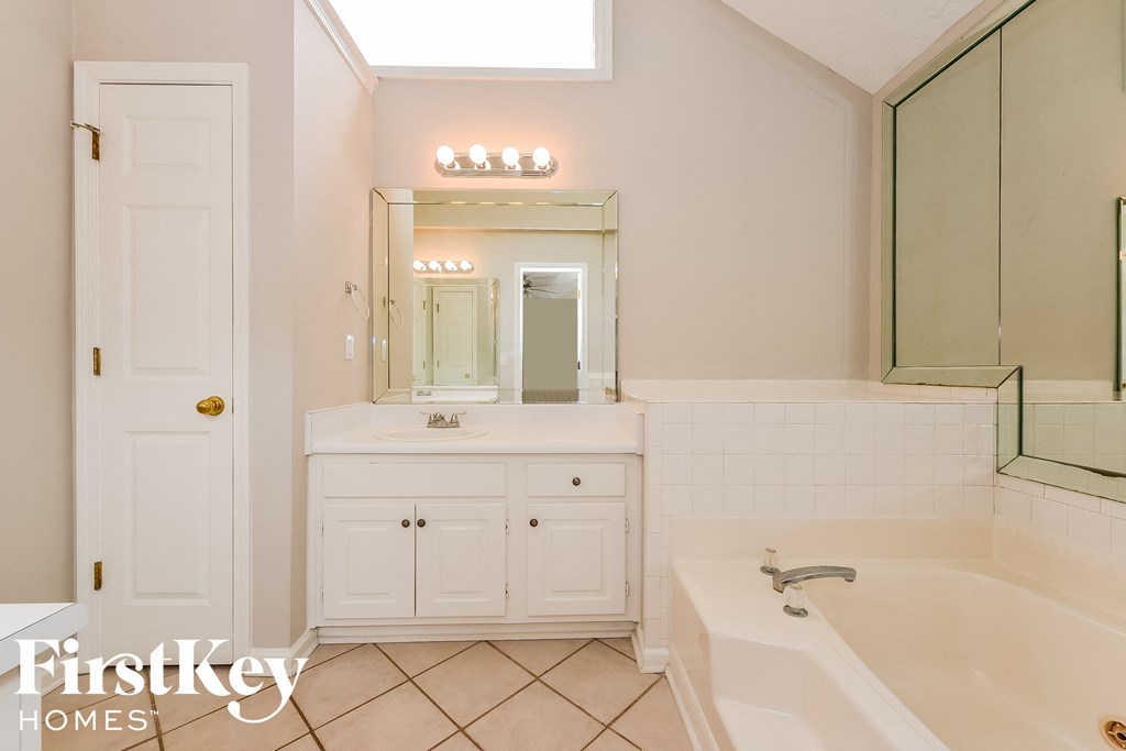 a bathroom with a tub and a sink and a mirror