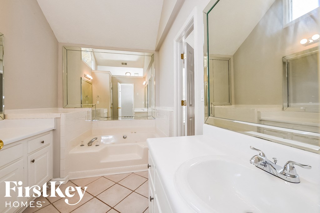 a bathroom with a tub and a sink and a mirror