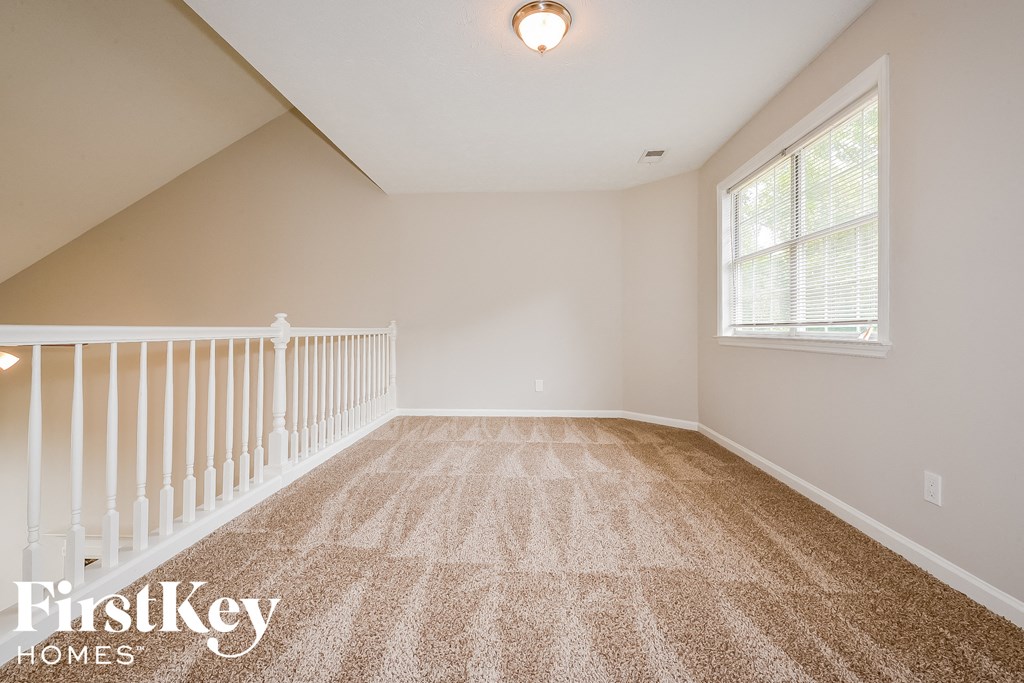 the attic of a home with a staircase and carpeted floors