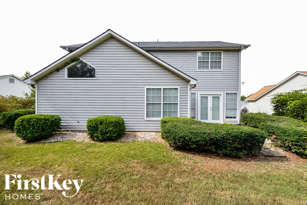 a blue house with bushes in front of it