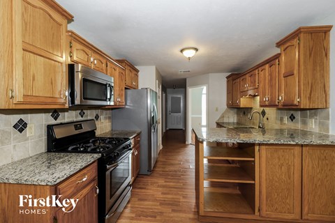 A kitchen with wooden cabinets and granite countertops.