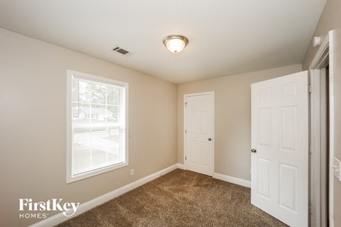 a bedroom with a closet and a door and a window