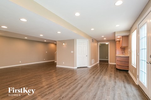 A spacious room with wooden floors and a white door.