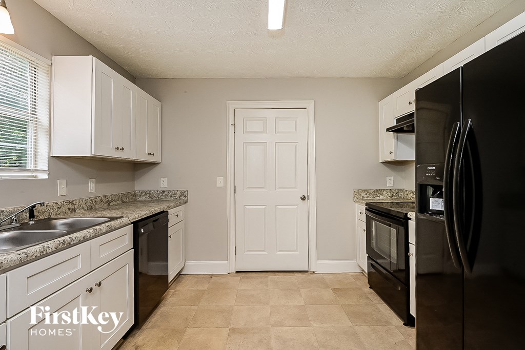 a kitchen with black appliances and white cabinets