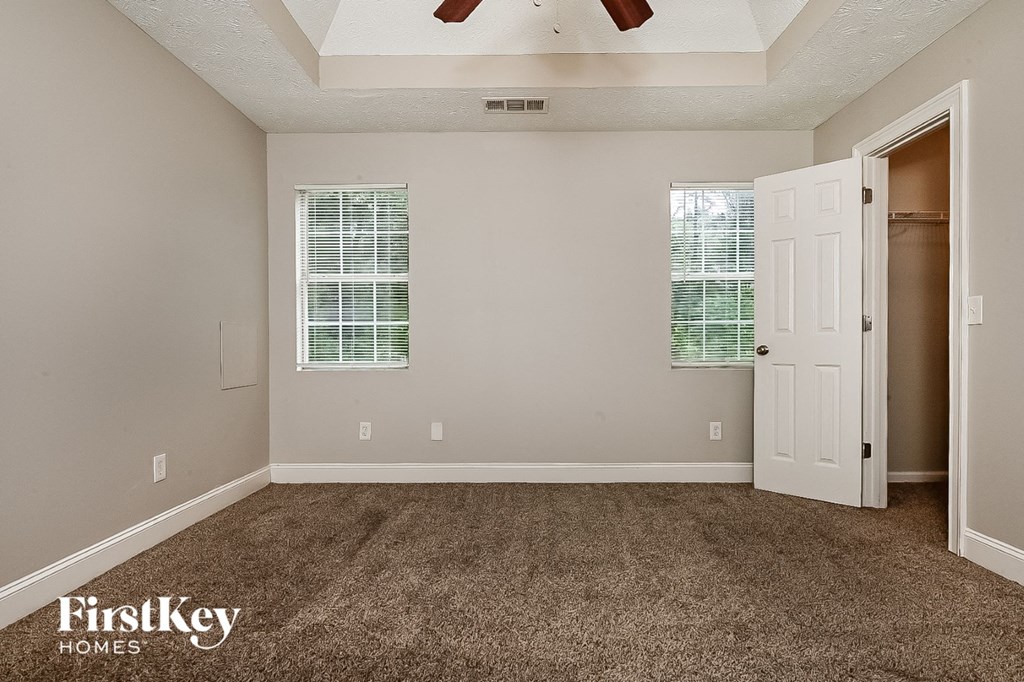a bedroom with carpet and a door to a closet