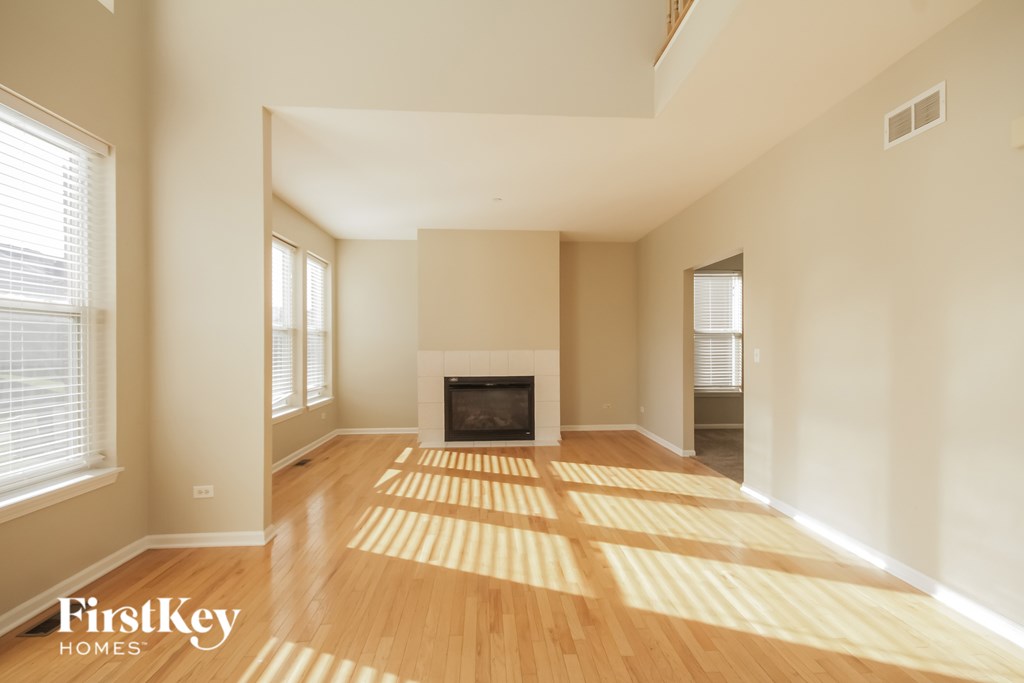 A spacious living room with a fireplace and wooden flooring.