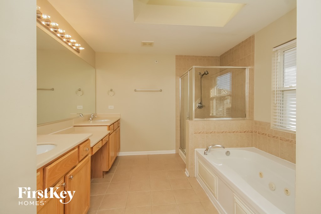 A bathroom with a tub, sink, and mirror.