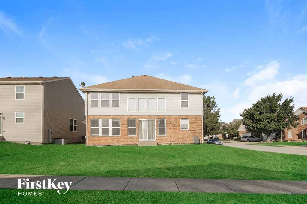 A row of houses with the words "FirstKey Homes" on the grass.