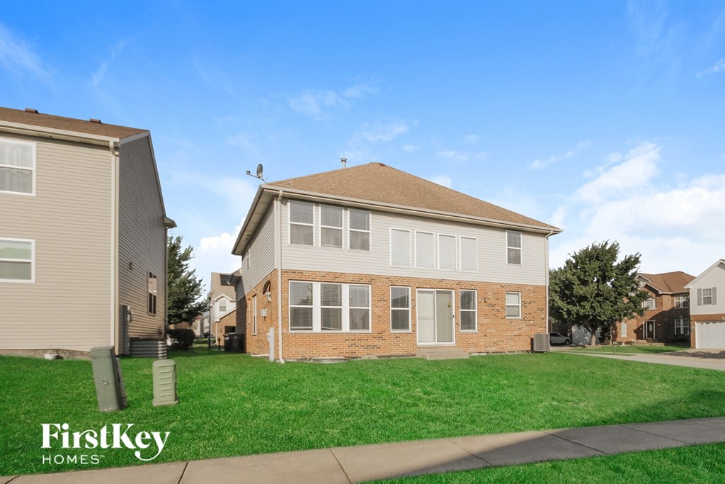 A house with a lawn in front of it and a sign that says FirstKey Homes.