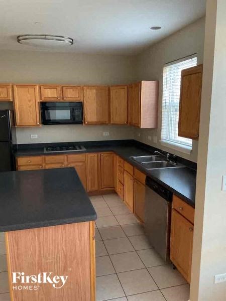 A kitchen with wooden cabinets and a black countertop.