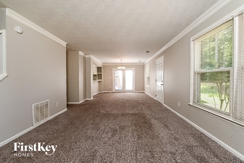 a spacious living room with carpet and a large window