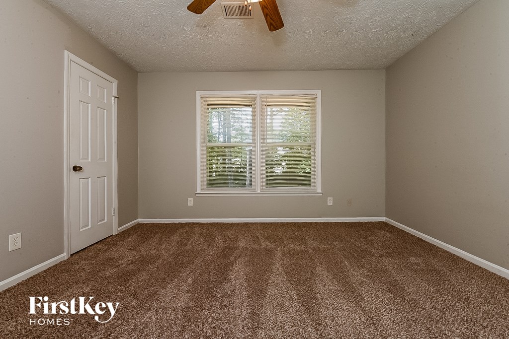 the master bedroom has a carpeted floor and a window