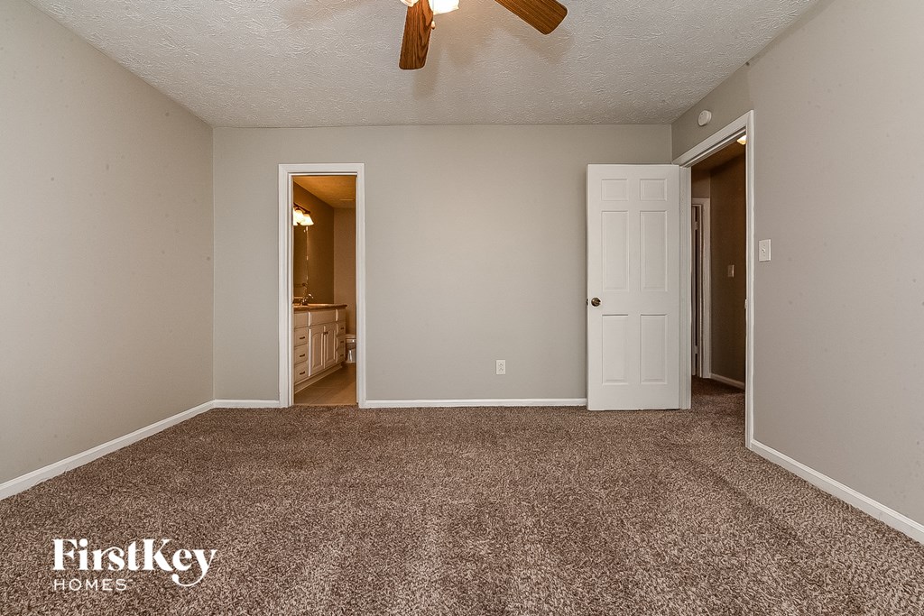 an empty living room with carpet and a ceiling fan