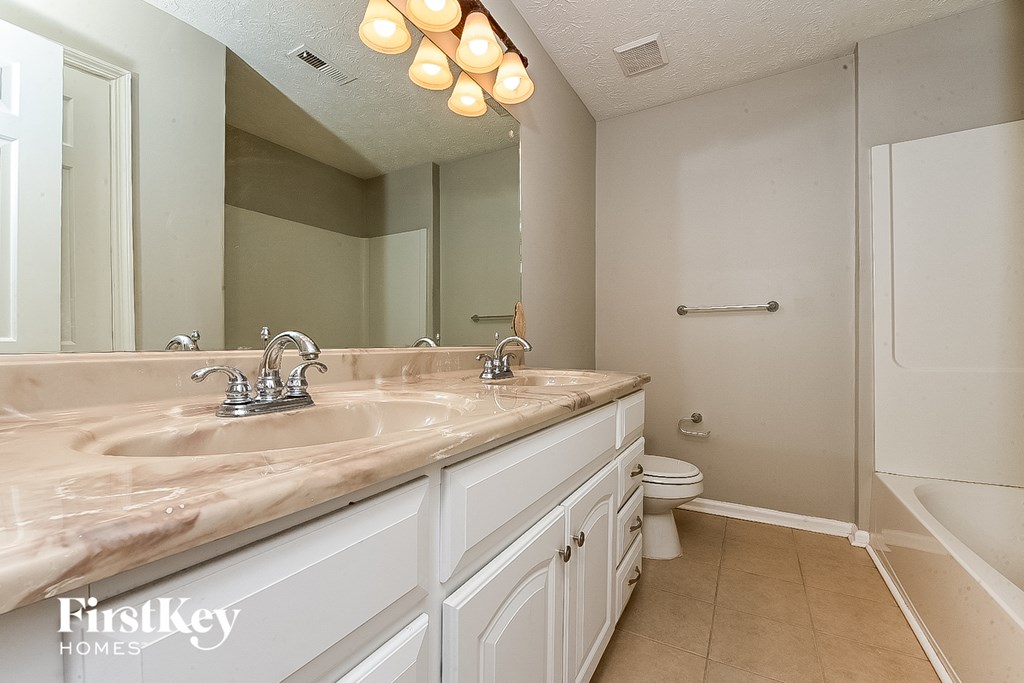 a bathroom with a sink and a toilet and a mirror