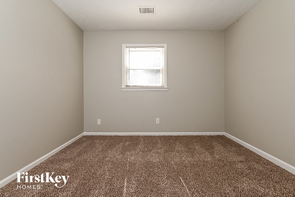 a room with a carpeted floor and a window