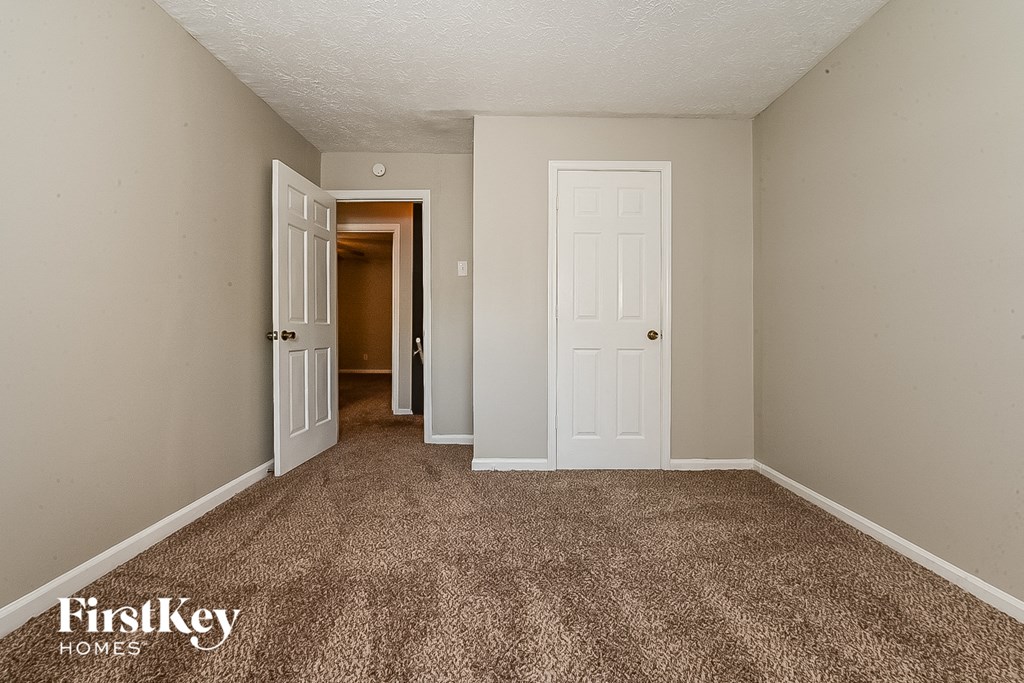 a bedroom with a carpeted floor and white doors