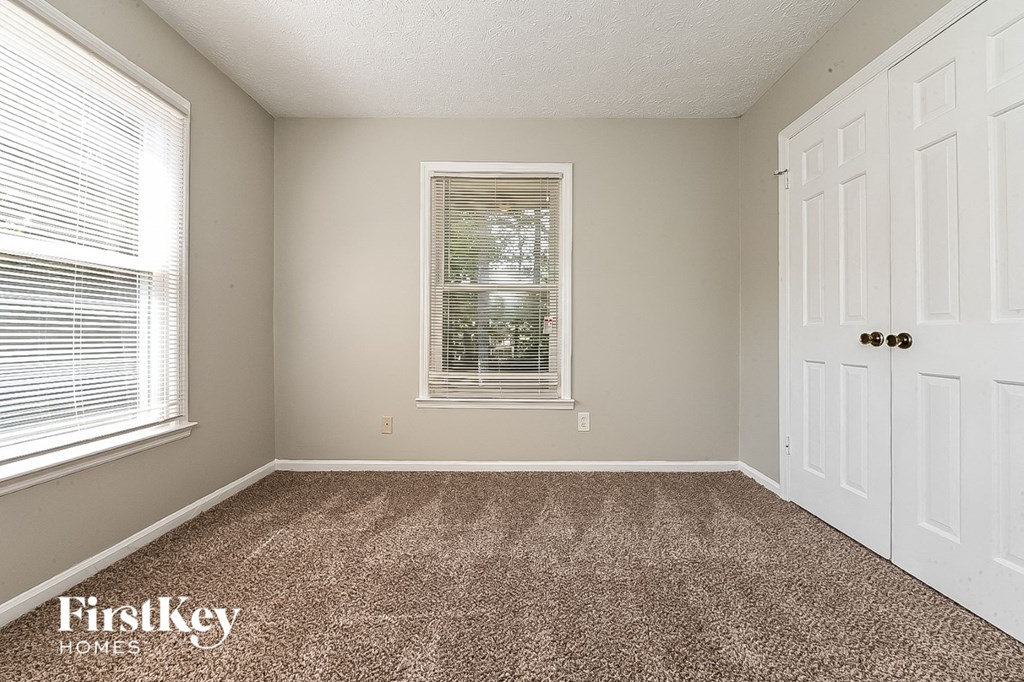 a bedroom with a carpeted floor and a window