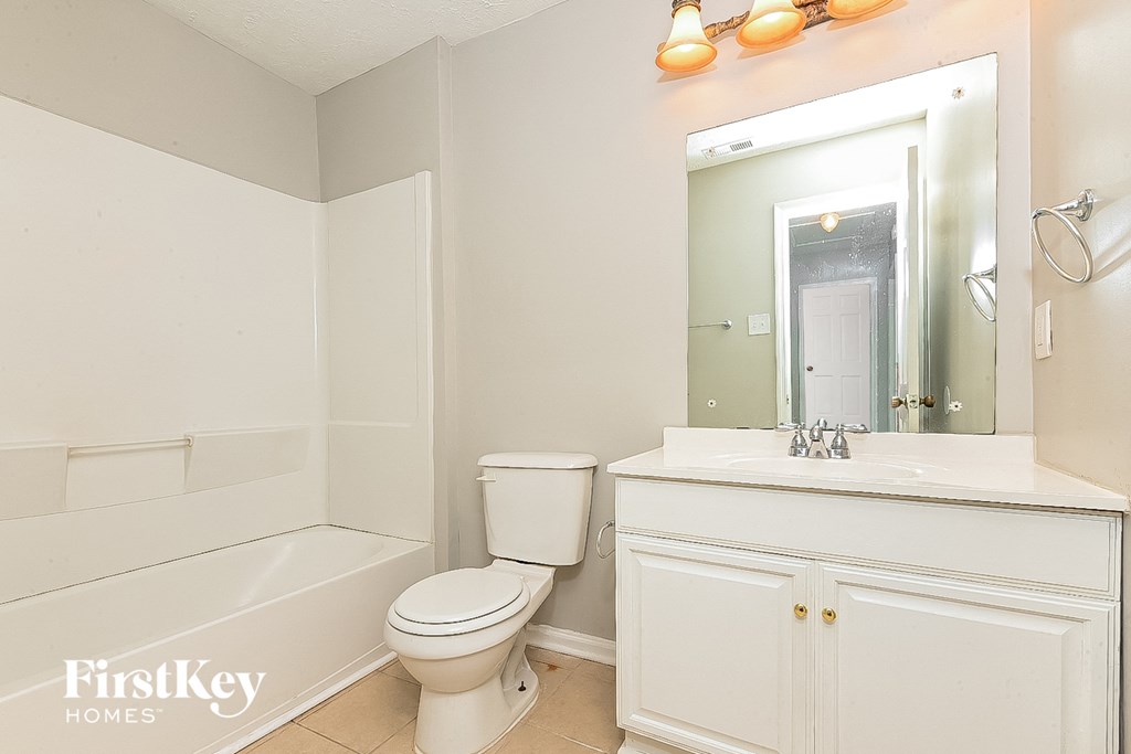 a bathroom with a sink toilet and a mirror