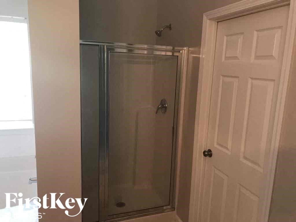 a bathroom with a shower and a white door