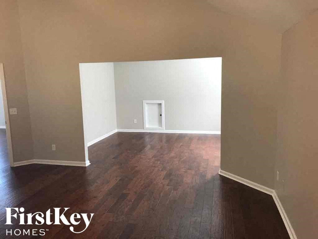 an empty room with hardwood flooring and white walls