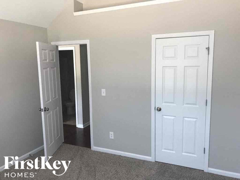 an empty room with a white door and a closet