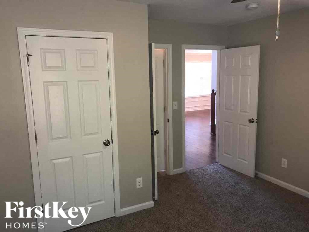 a room with two closets and a door and a hallway with a door open