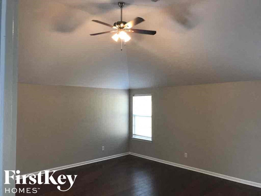 a empty room with a ceiling fan and a window