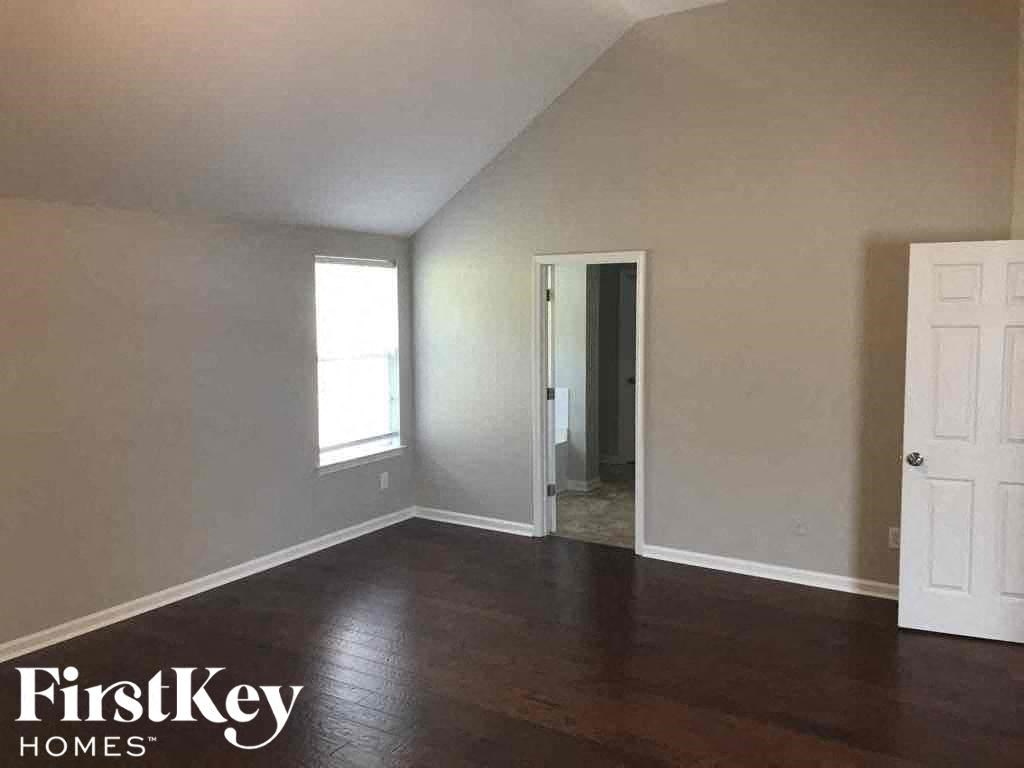 an empty living room with wood floors and a white door