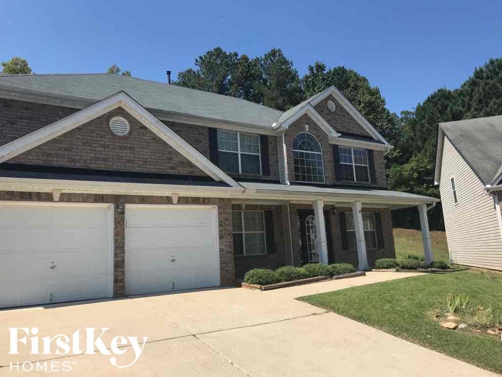 a brick house with two garage doors and a driveway