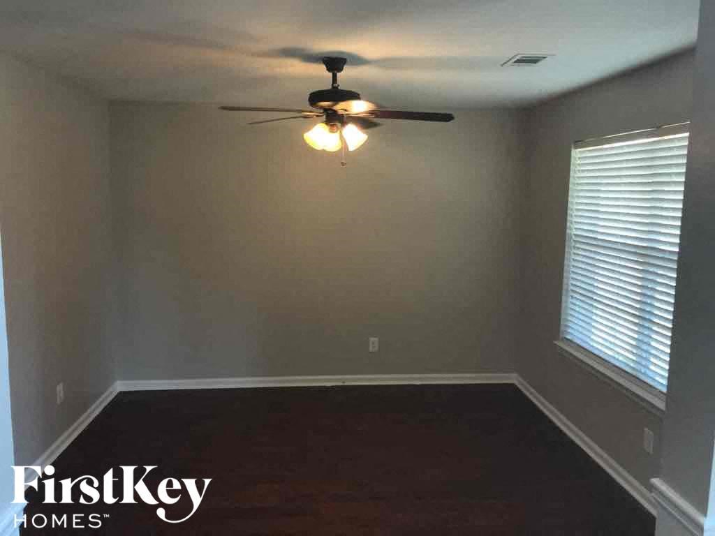 a empty room with a ceiling fan and a window