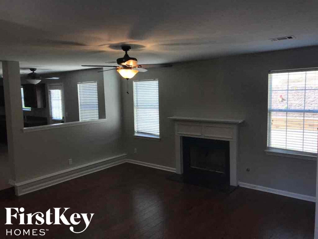 a living room with a ceiling fan and a fireplace