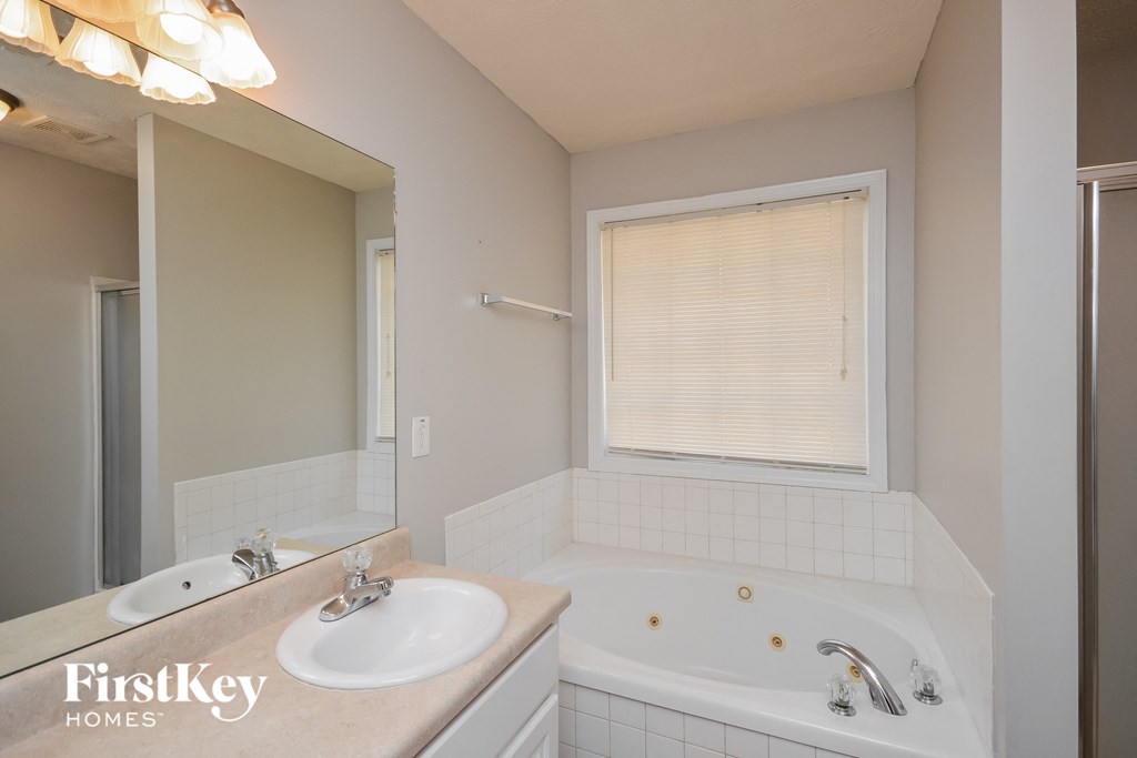 a bathroom with a tub and a sink and a mirror