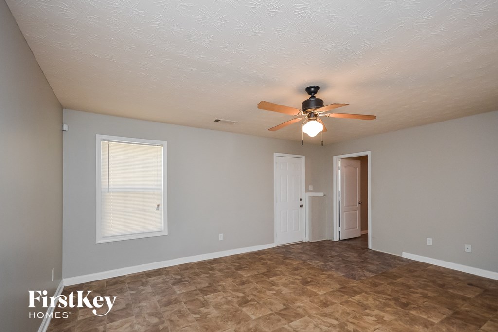 the living room of an empty house with a ceiling fan